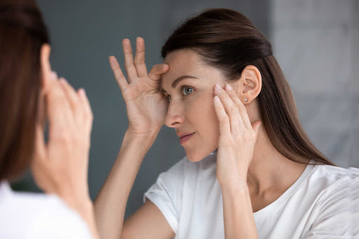 A woman is looking at herself in the mirror.